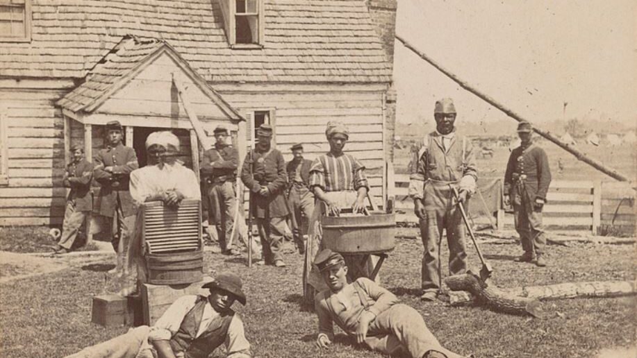 group of African American refugees with Union soldiers in front of General Lafayette's headquarters at Allen's farm house near Williamsburg Road